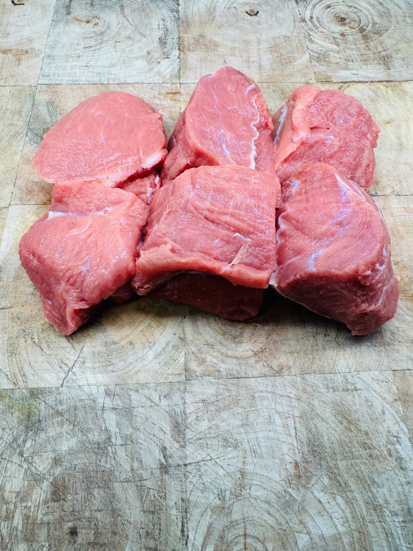 Morceaux de blanquette de veau limousine d'origine France sur planche en bois, viande tendre idéale pour plats mijotés.