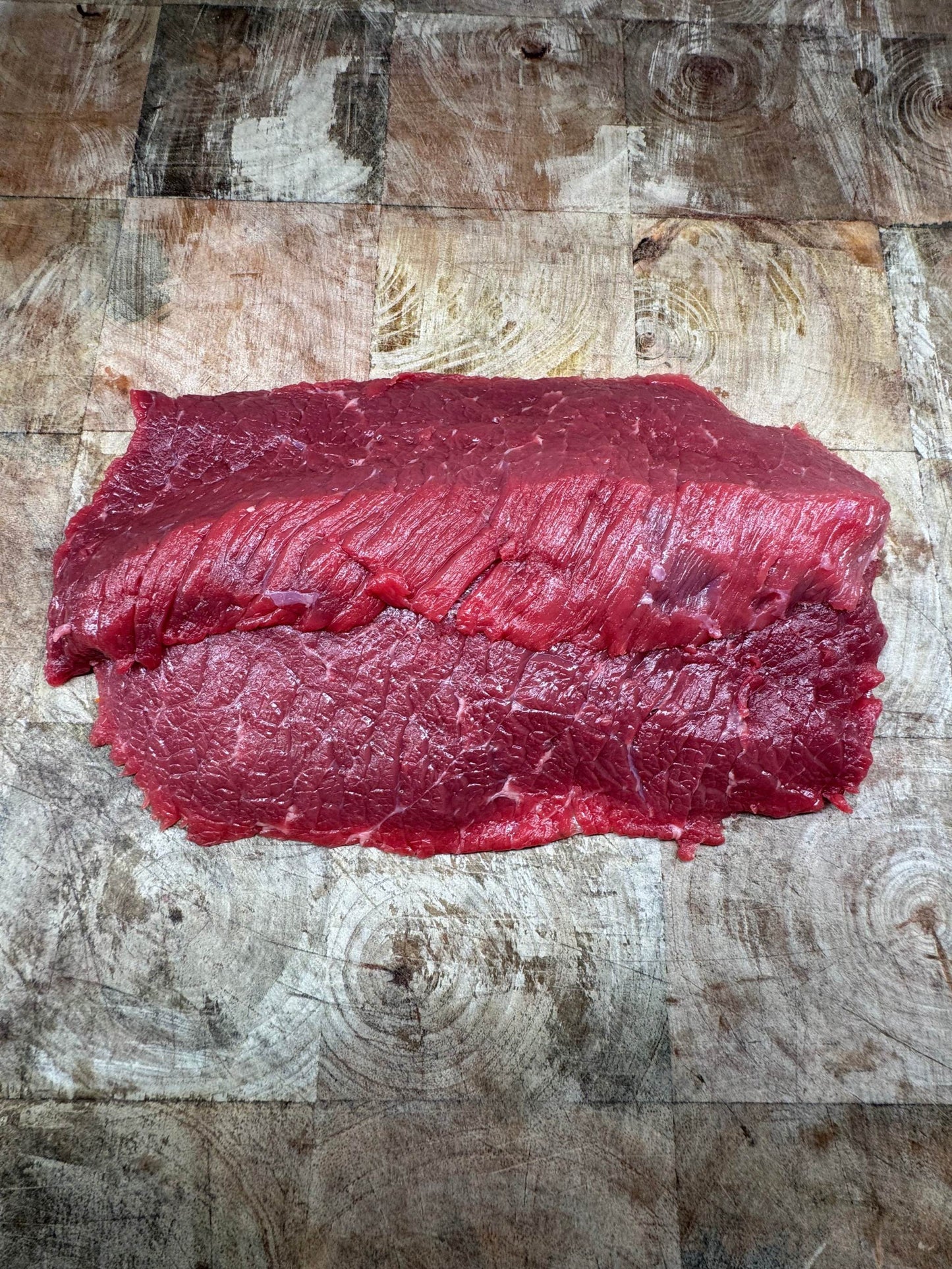 Sur planche de bois, cette bavette d’aloyau de génisse limousine est une viande rouge fibreuse et juteuse.