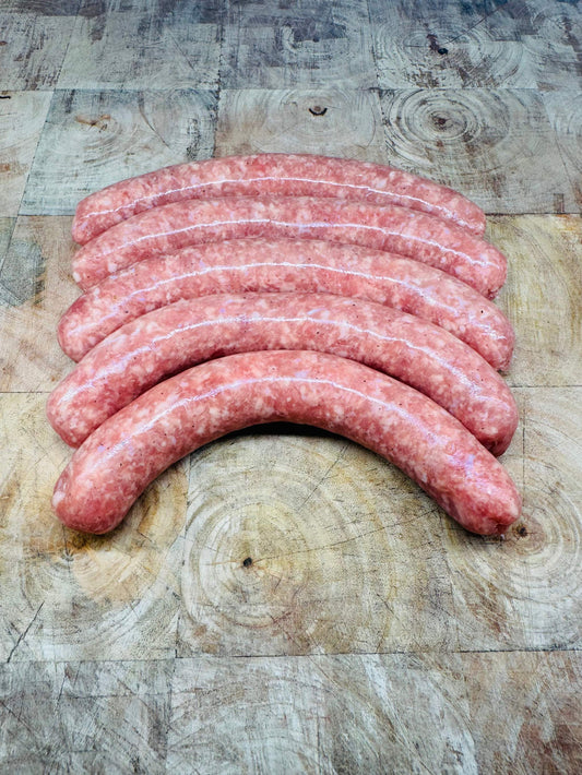 Chipolatas françaises 500g sur planche en bois, savoureuses et légères.